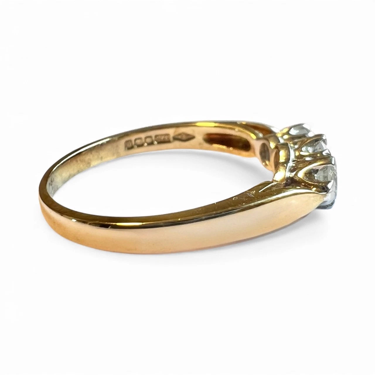 Gold ring with a diamond on a white background. Close up side view 