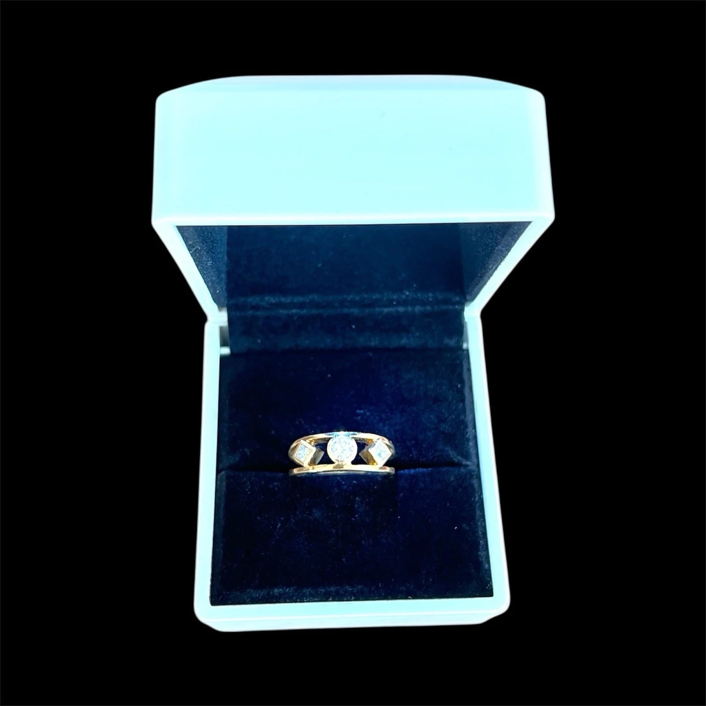The stone diamond Gold ring in a white jewellery box on a black background