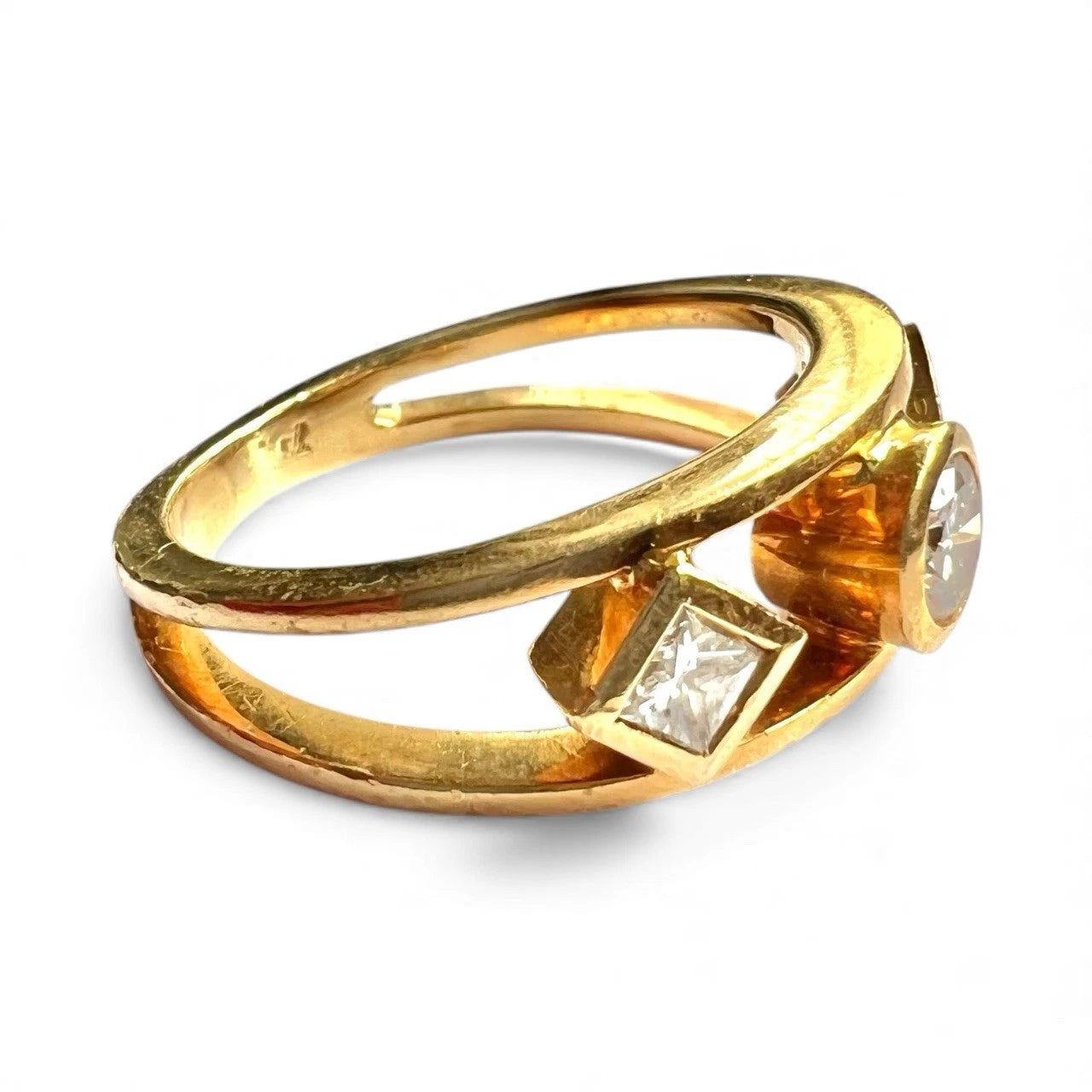 Gold ring with three diamonds on a white background. Close up side view. 