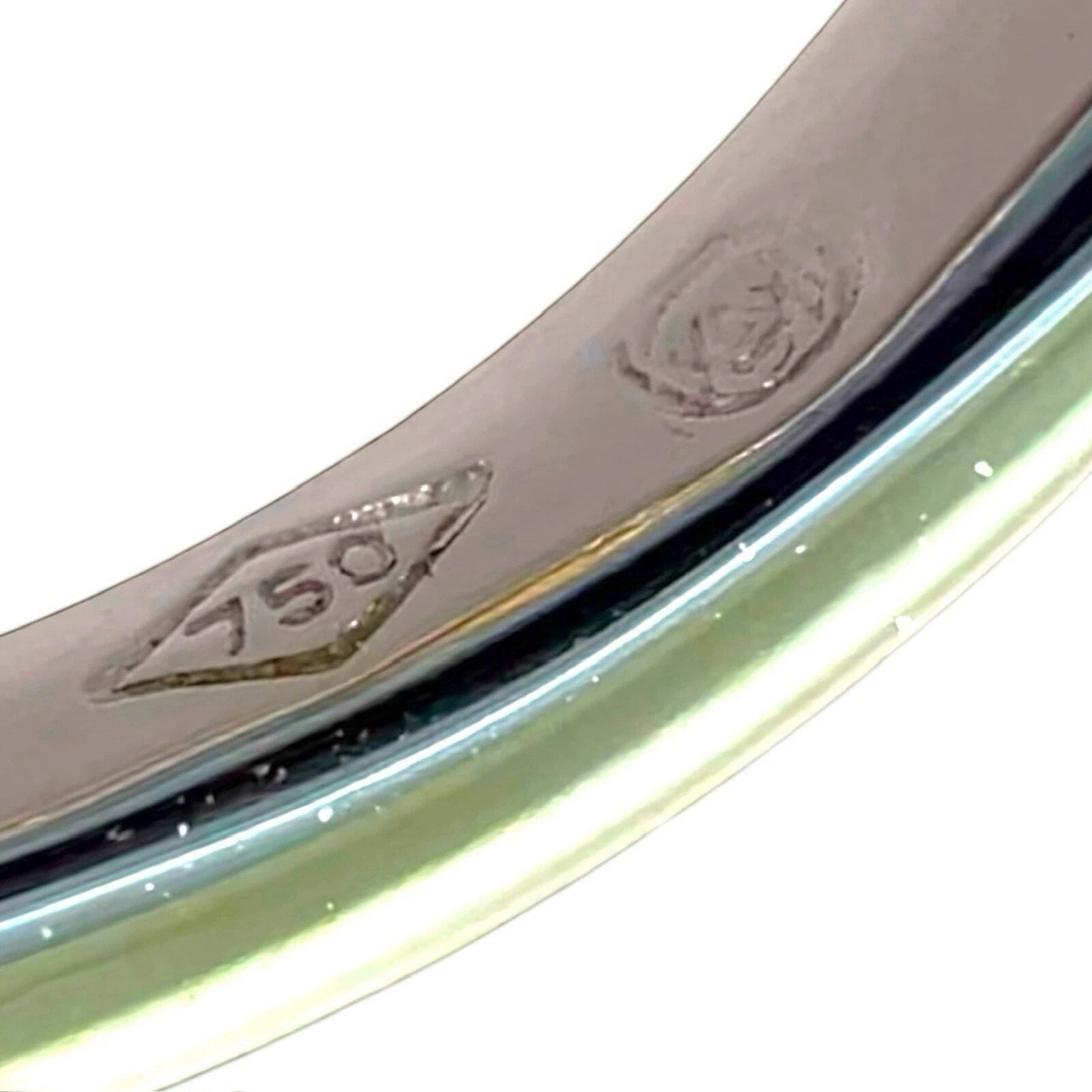Close-up of a white gold stamp 750 for 18ct gold on a white background