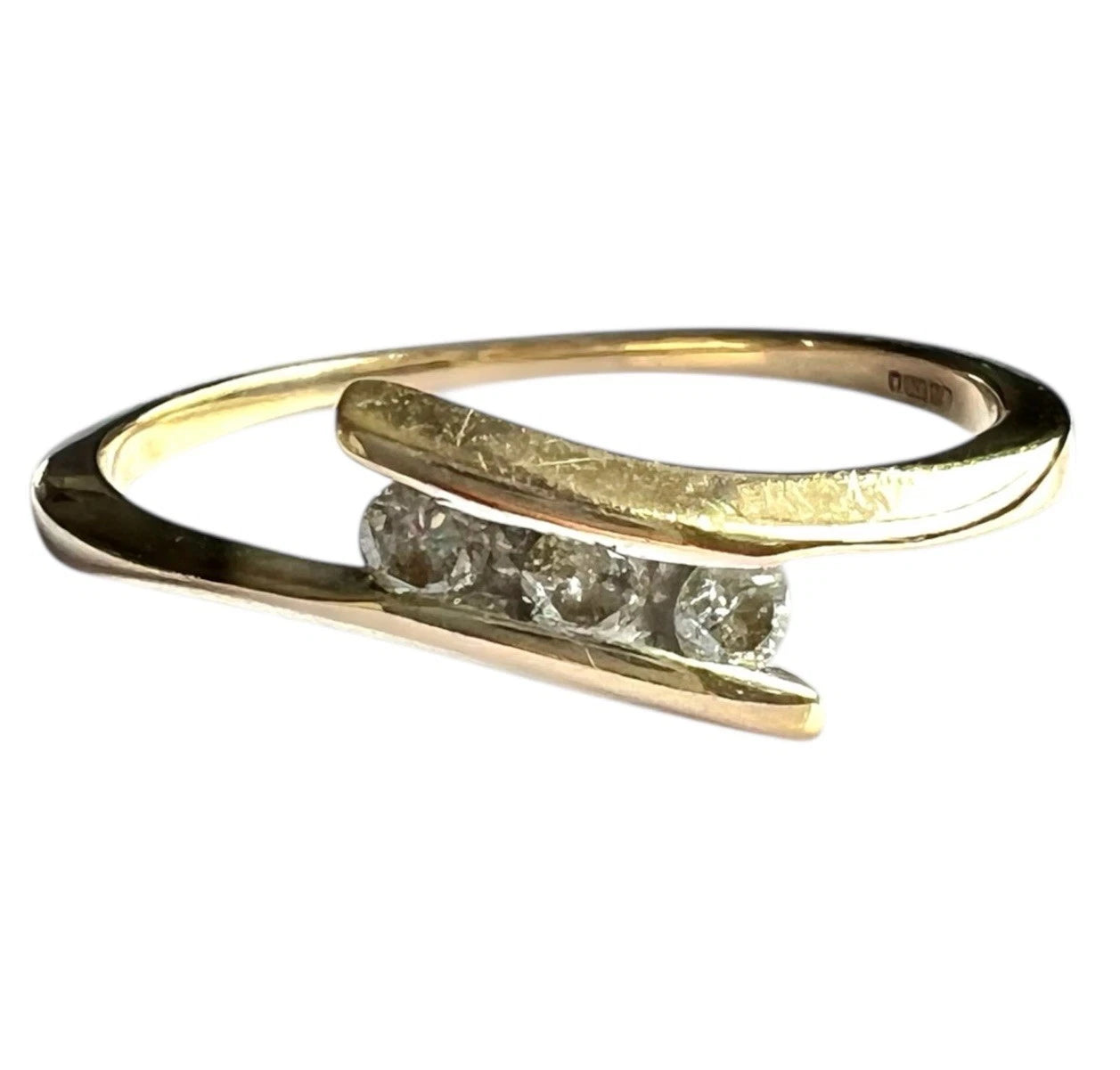 Gold ring with three diamonds on a white background close up front view 