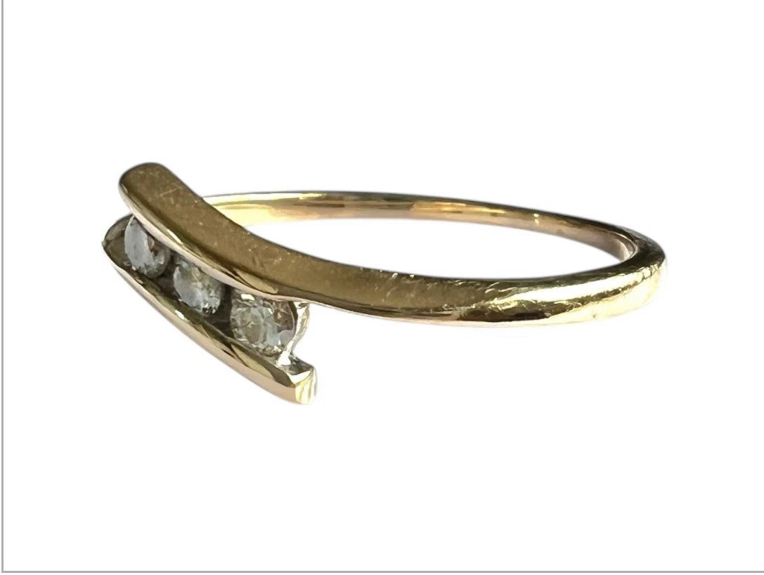 Gold ring with three diamonds on a white background close up side view 