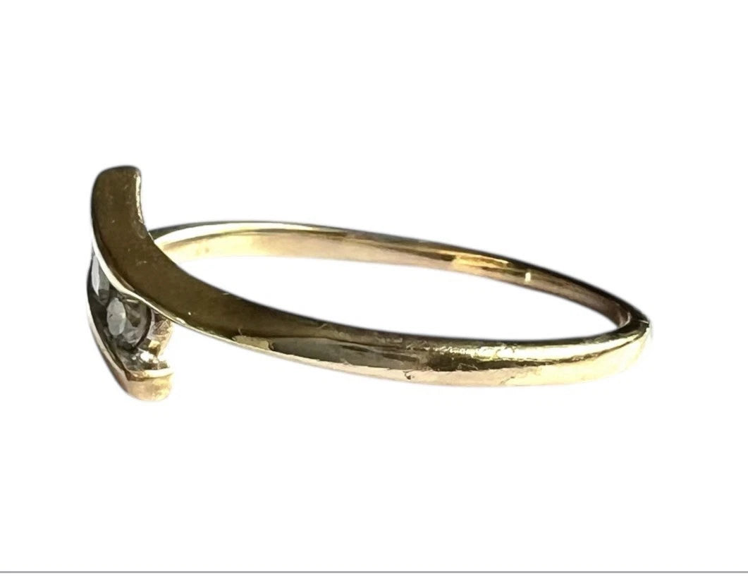 Close up side view gold ring with a diamond on a white background