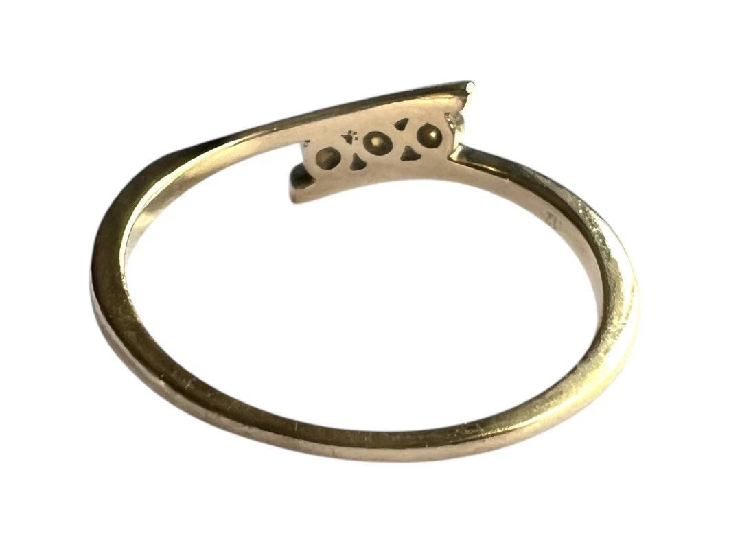 Gold ring with three diamonds on a white background rear view close up of setting and gold band 