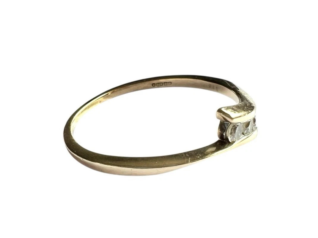 Gold ring with a diamond on a white background close up side view of gold band 