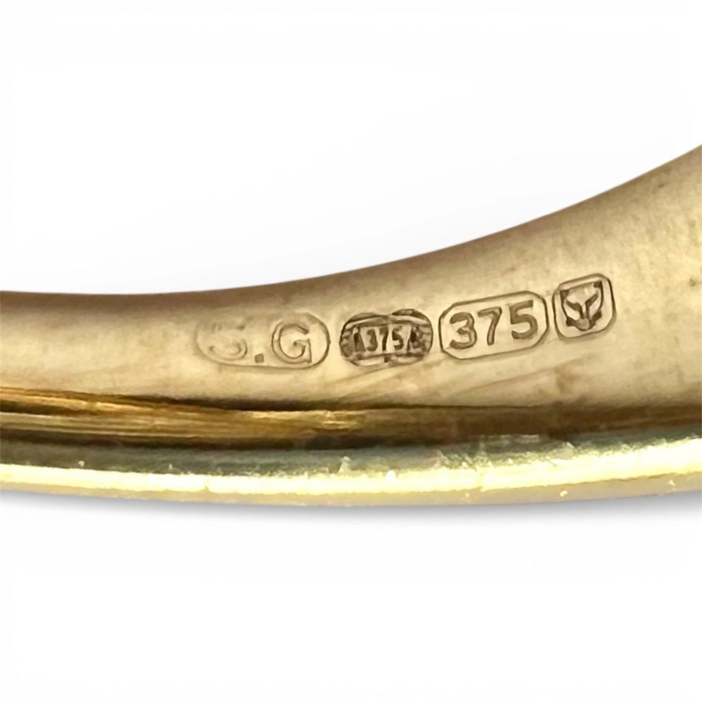 Gold ring with visible hallmarking on a white background
