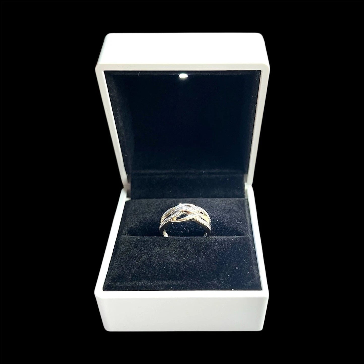 Gold diamond ring in an open jewellery box on a black background
