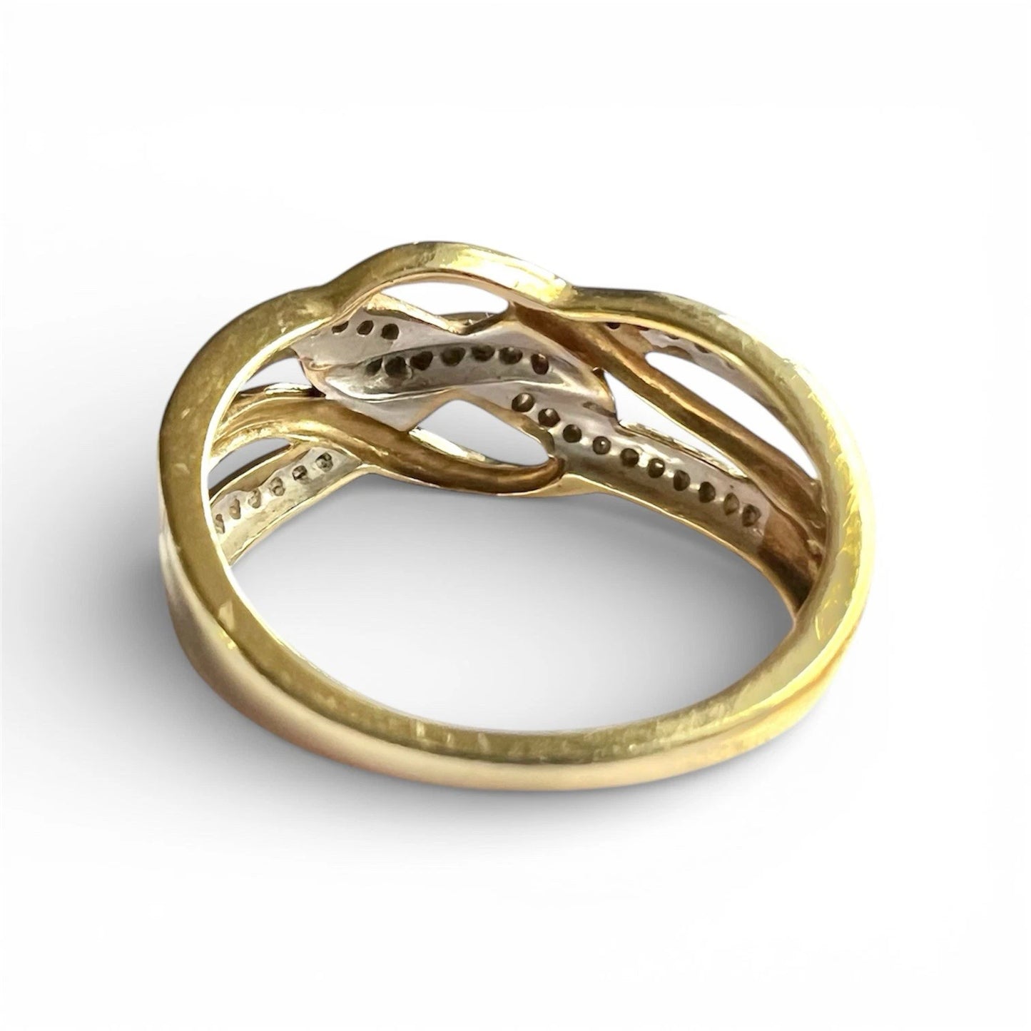 Rear view close up of setting for gold ring with intricate design on a white background