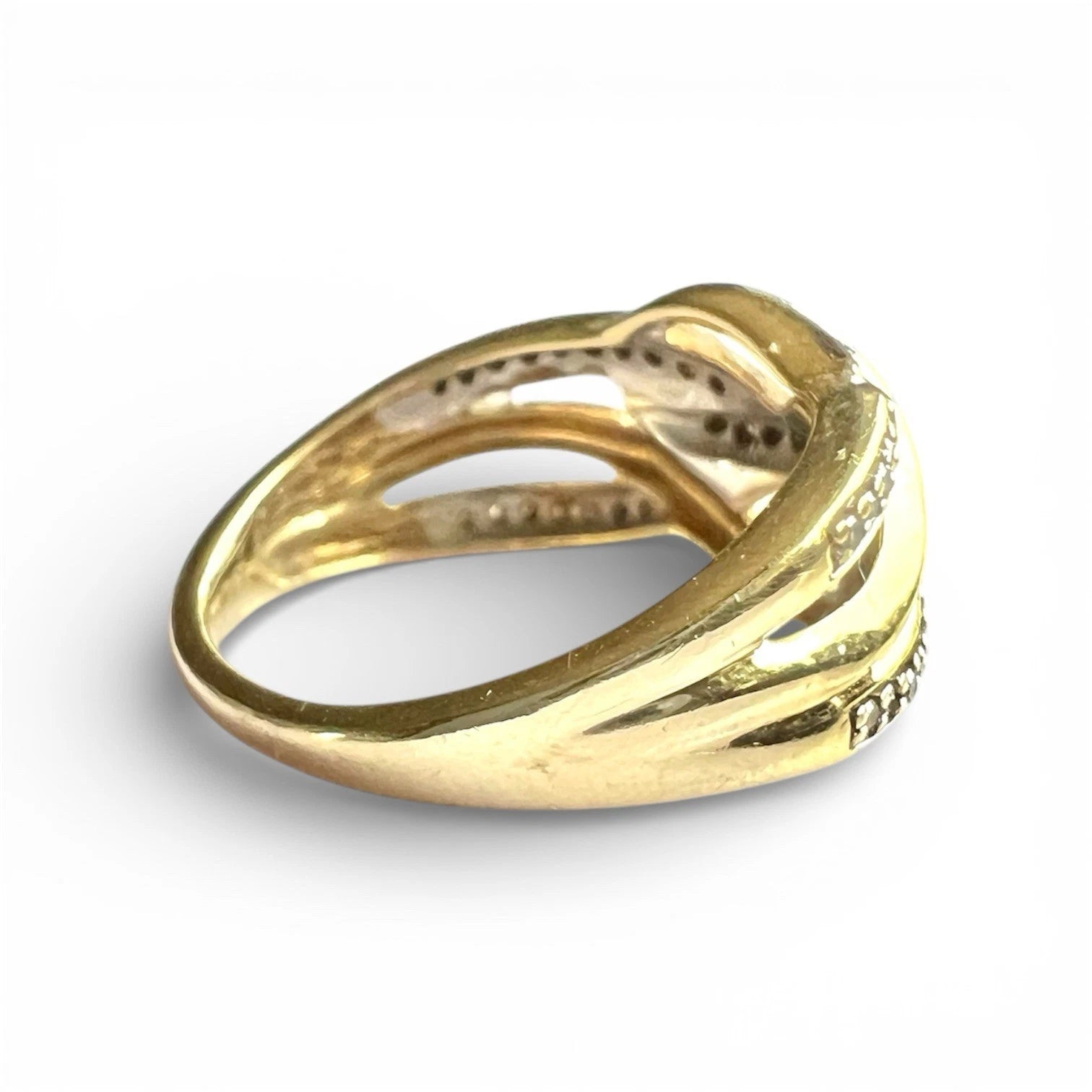 Close up side view gold diamond ring with intricate design on a white background
