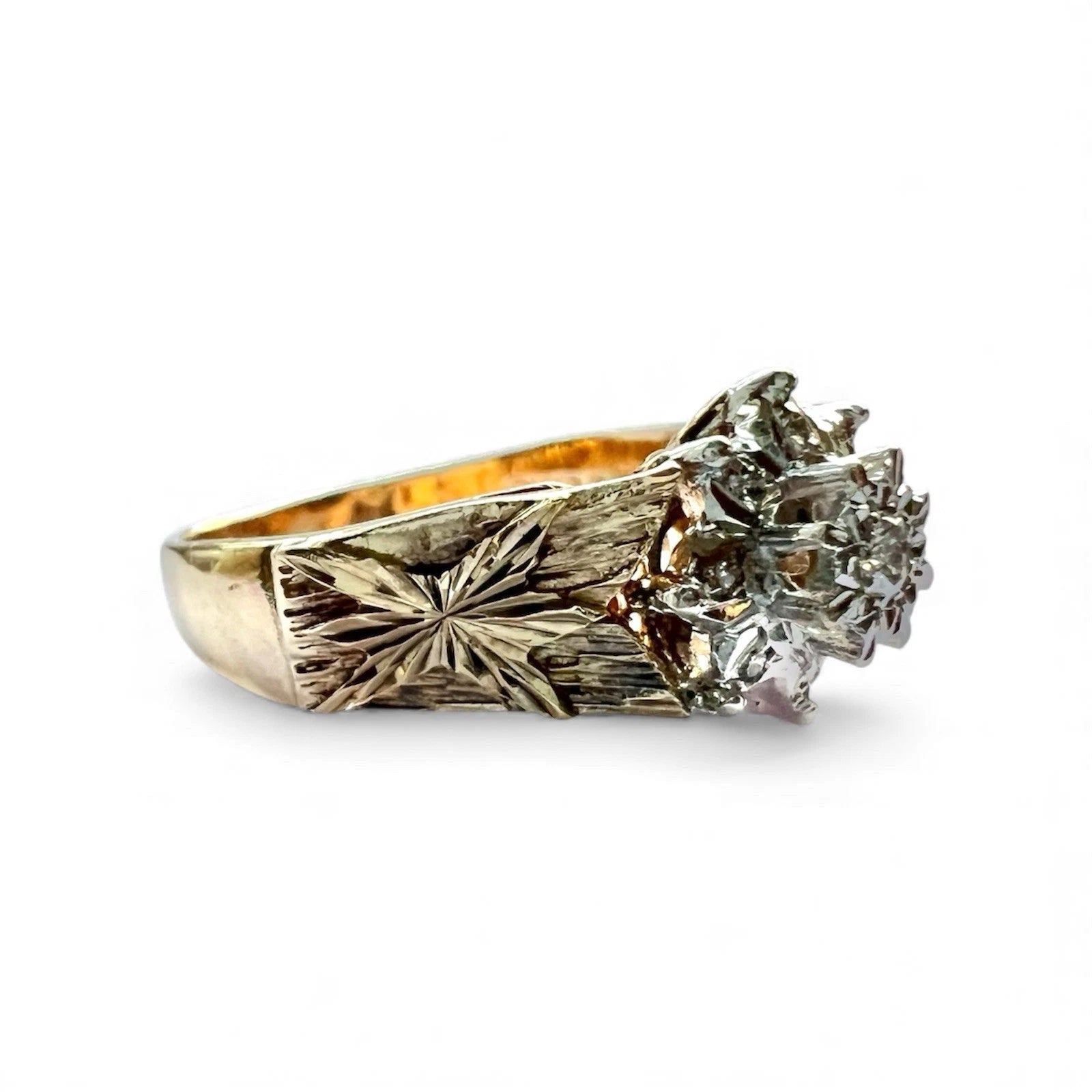 Gold ring with intricate design and diamond on a white background