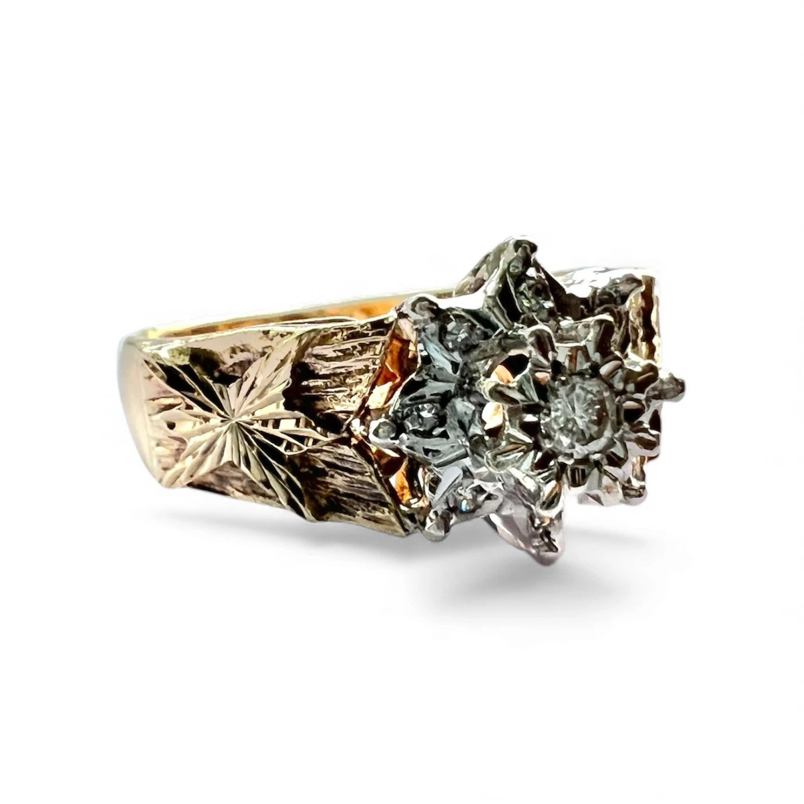 Gold ring with intricate design and embedded gemstones on a white background