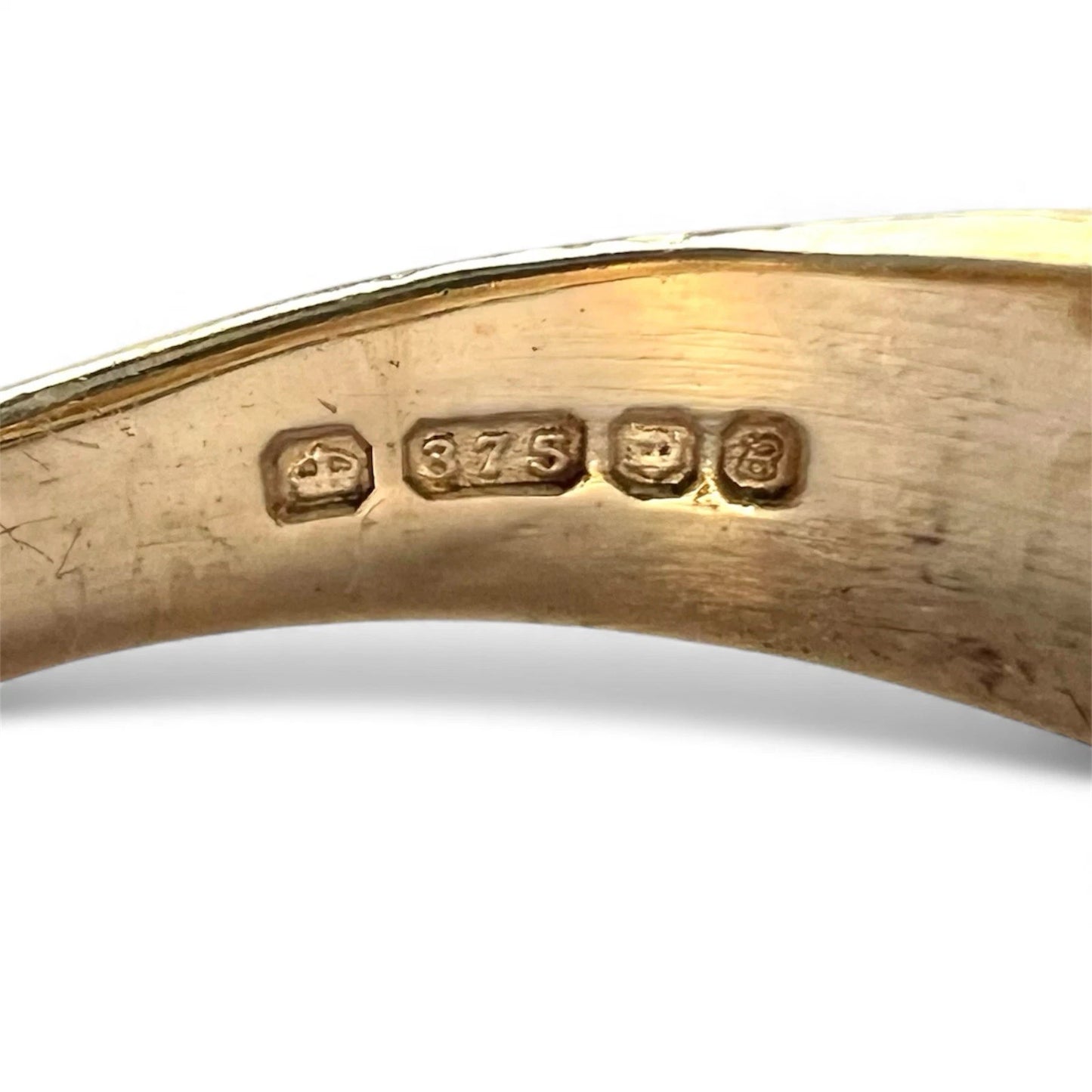 Gold ring with hallmarking on a white background