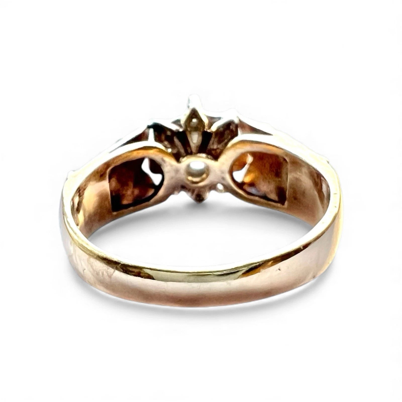 Gold ring with a central diamond on a white background