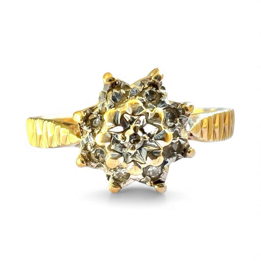 Gold flower cluster ring with a diamond's on a white background, close up front view 
