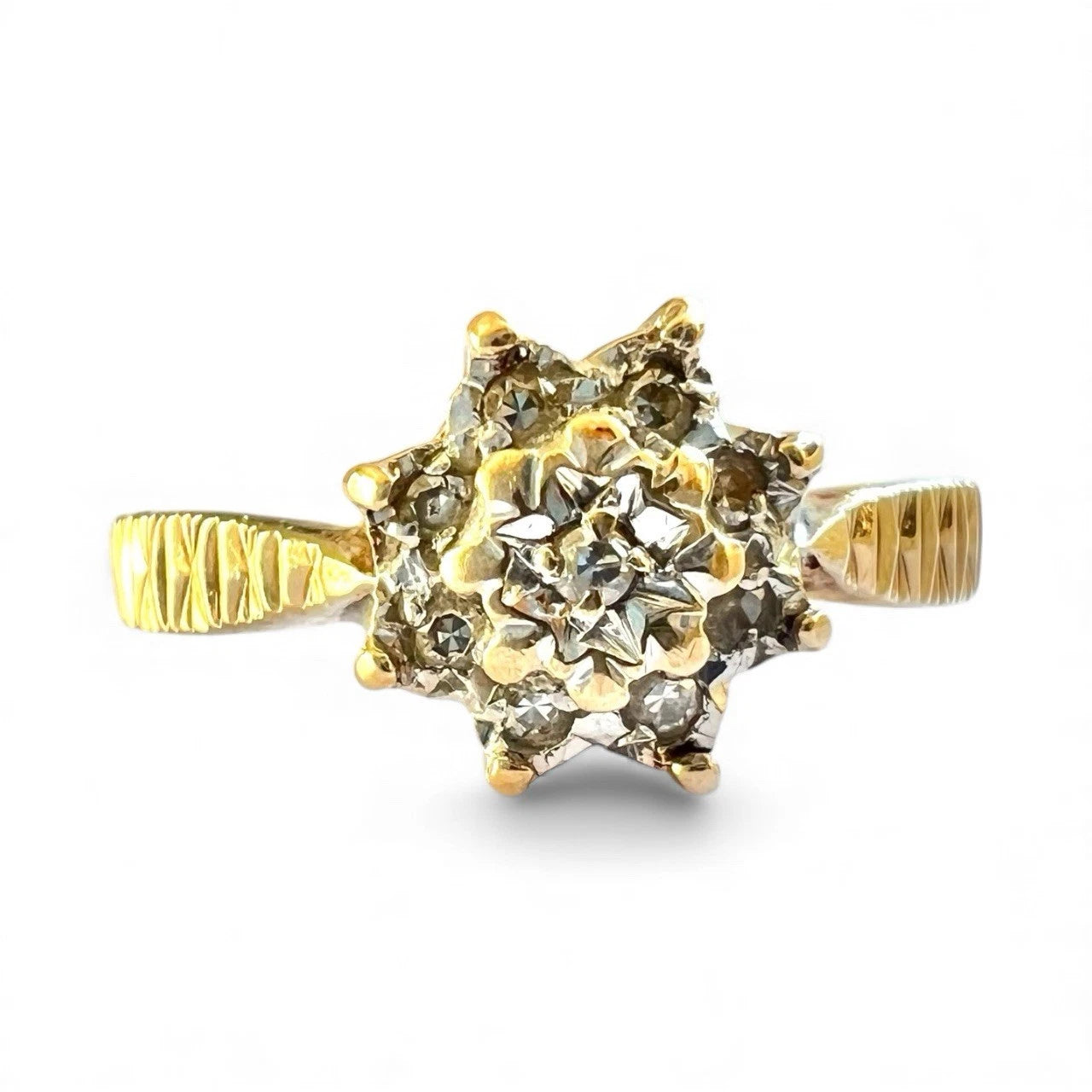 Gold cluster ring with diamonds on a white background close up front view 