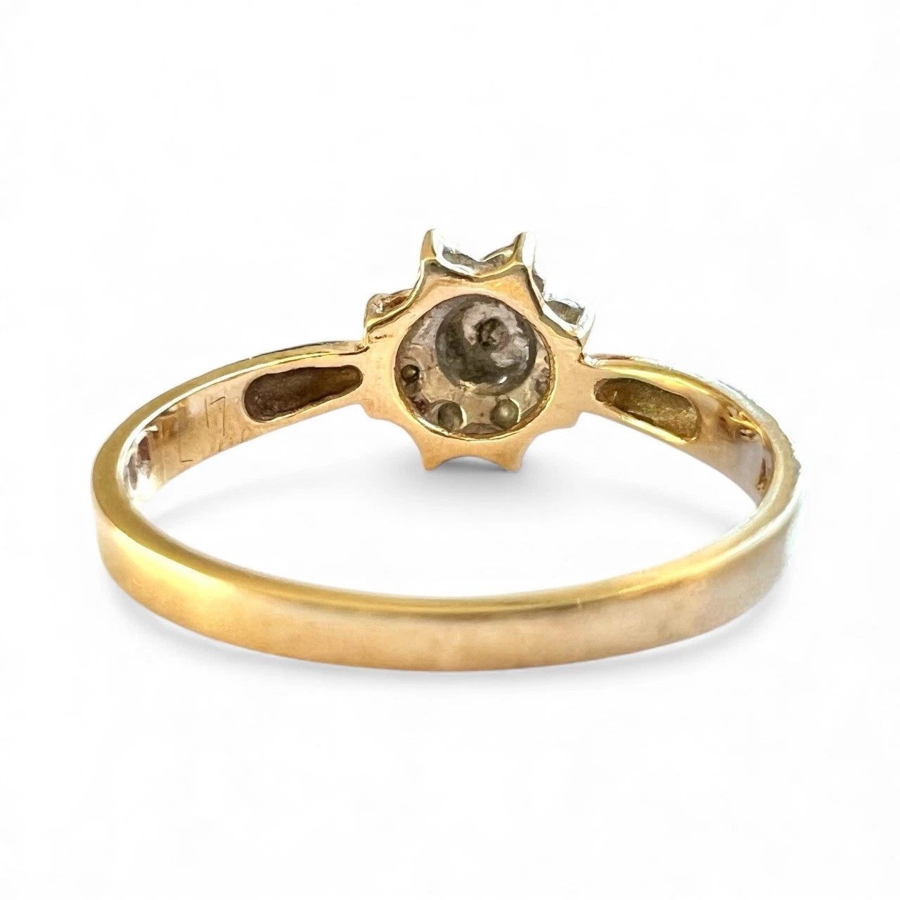 Gold diamond ring with a unique design on a white background, close-up rear view  of setting and gold band. 