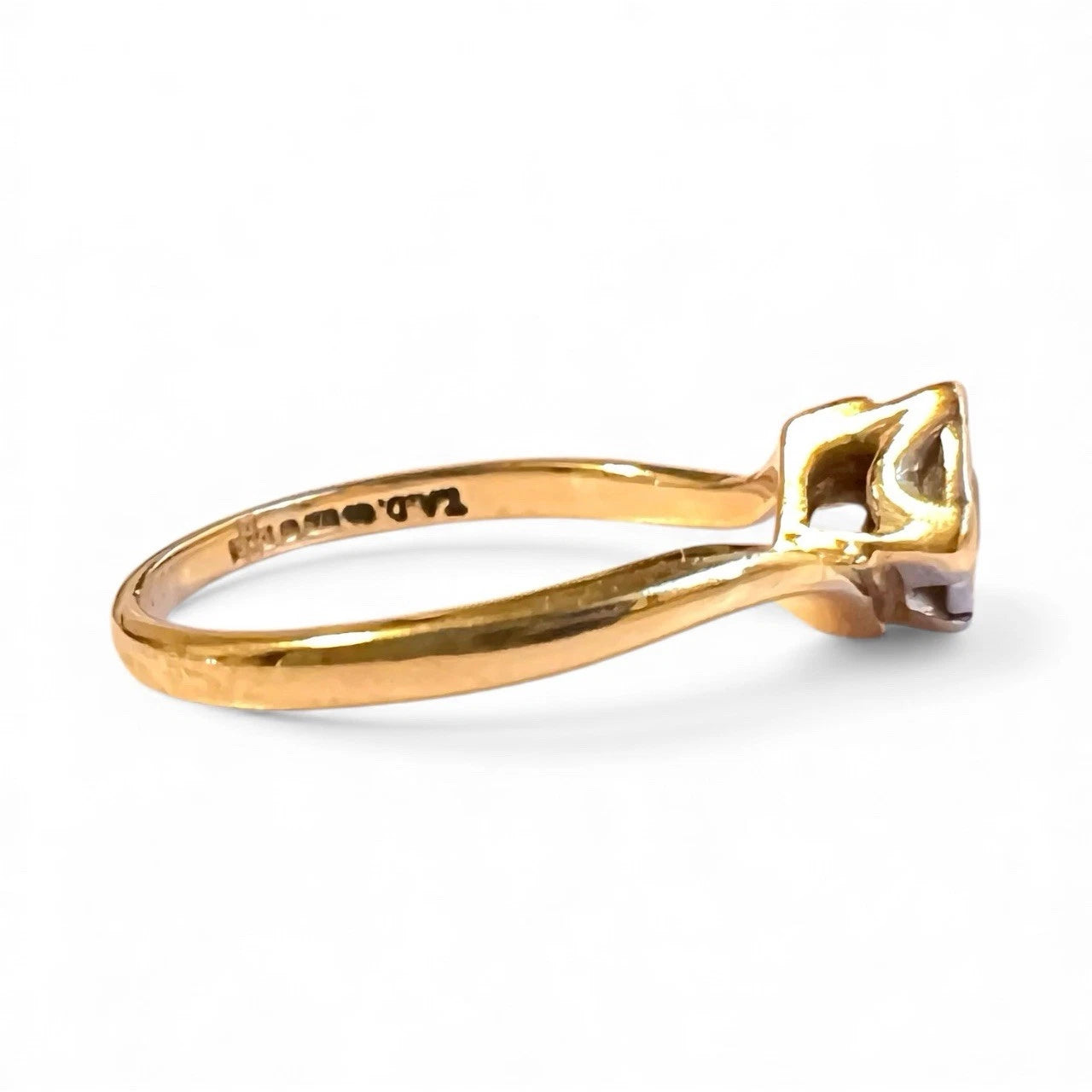 Gold ring with a diamond on a white background