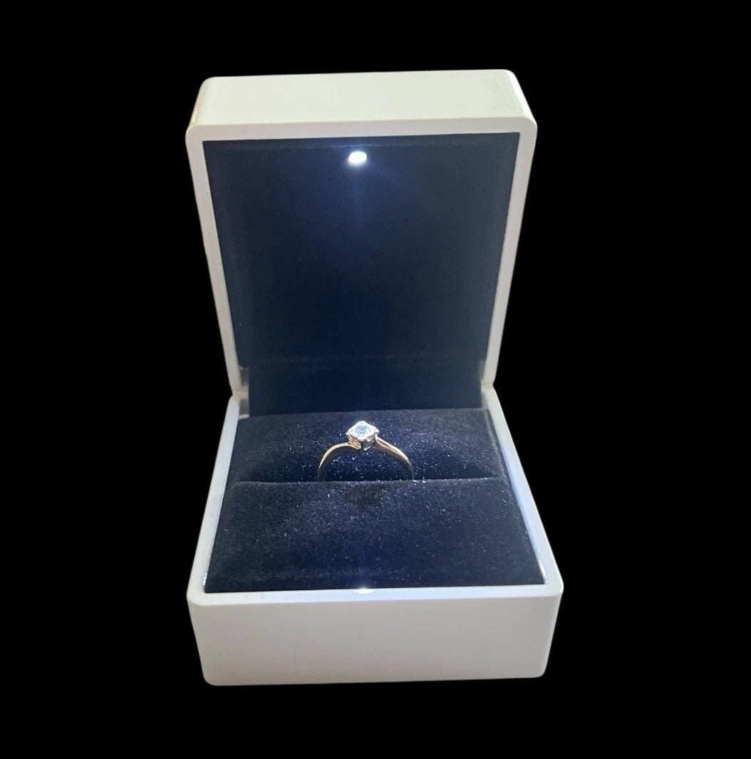 Diamond ring in a white box with a black interior