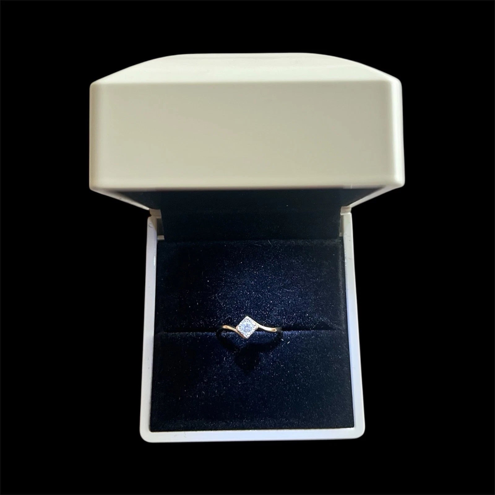 Diamond ring in an open jewelry box on a black background