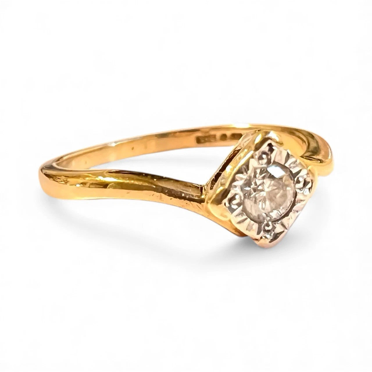 Gold ring with a diamond on a white background