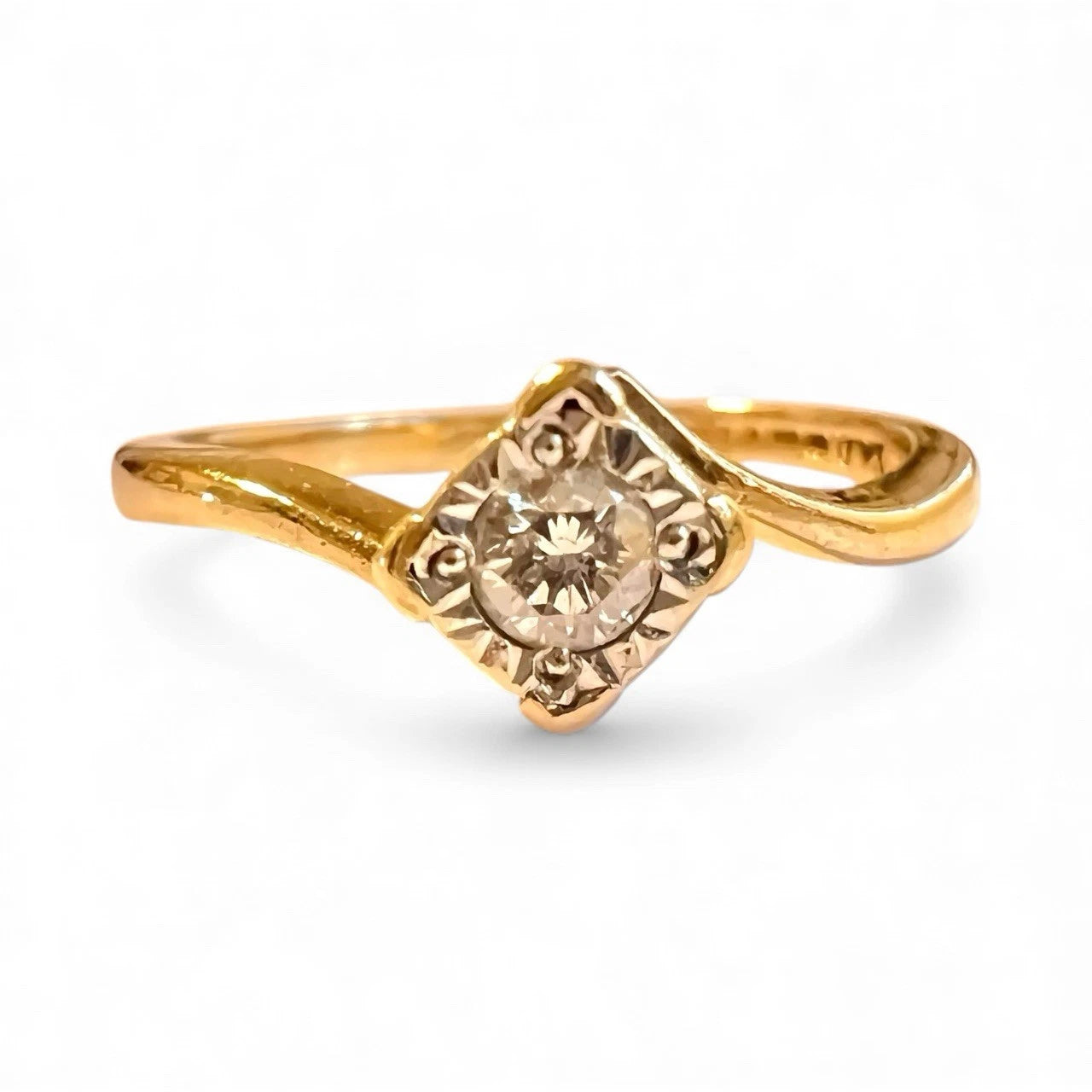 Gold ring with a diamond on a white background