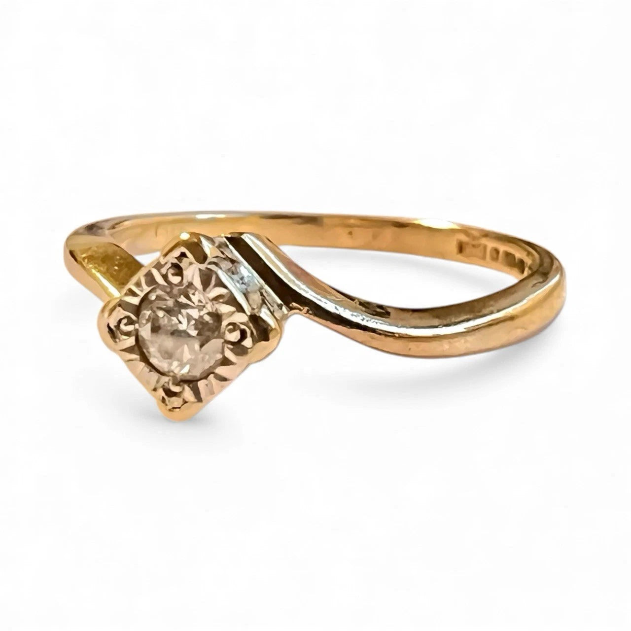 Gold ring with a diamond on a white background