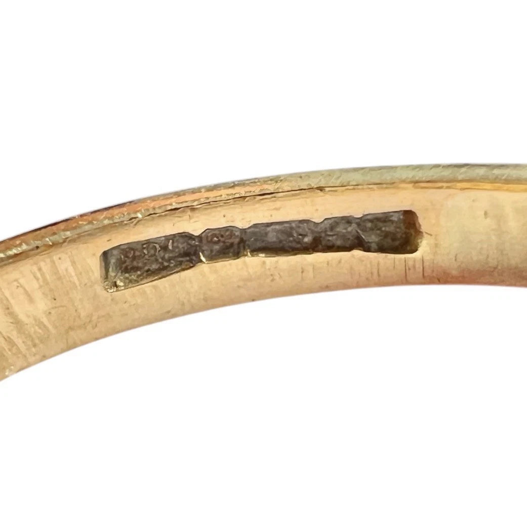 Gold ring with a hallmark on a white background