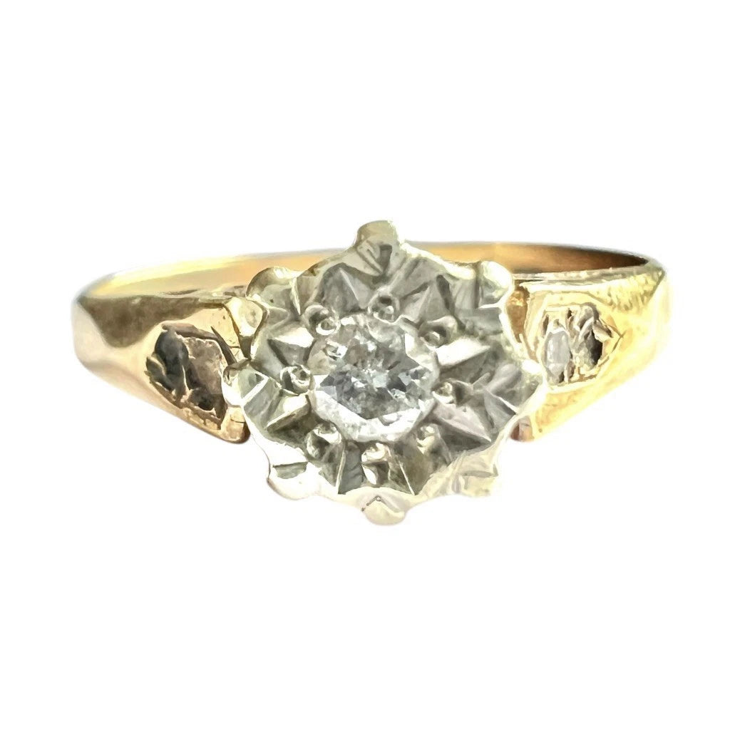 Gold cluster ring with a diamond on a white background, close up front view of setting 