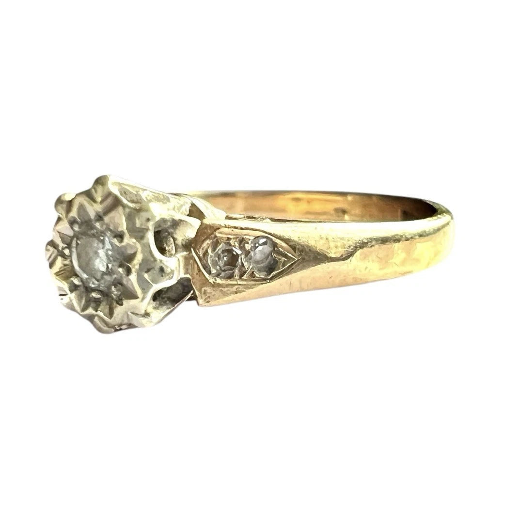 Vintage Gold diamond solitaire ring with diamond accents on a white background, close up side view 