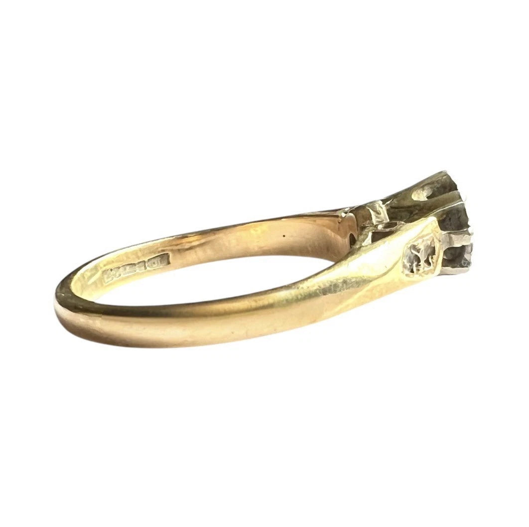 Gold solitaire ring with a diamond on a white background, close up side view 