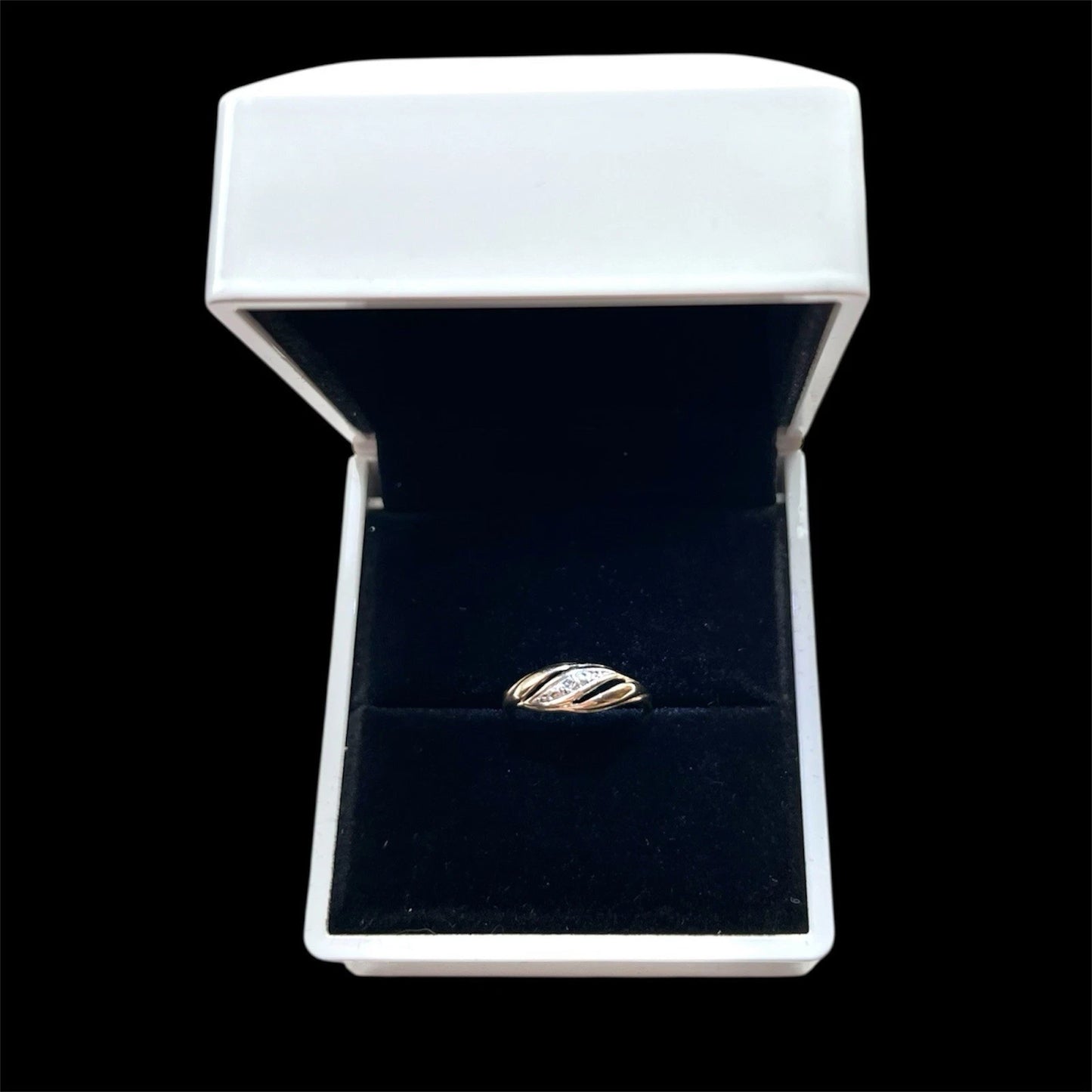 Gold ring centred with diamond in a white box on a black background