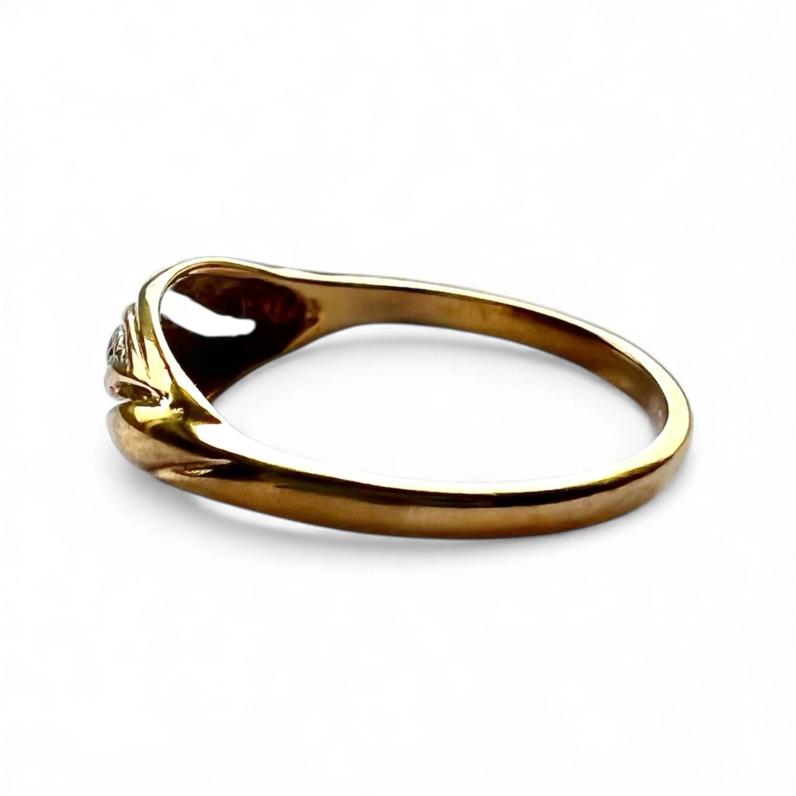 side view gold ring with a diamond on a white background