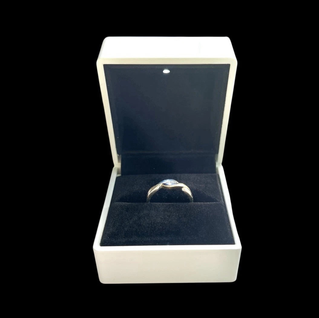 Gold ring in an open jewellery box on a white background