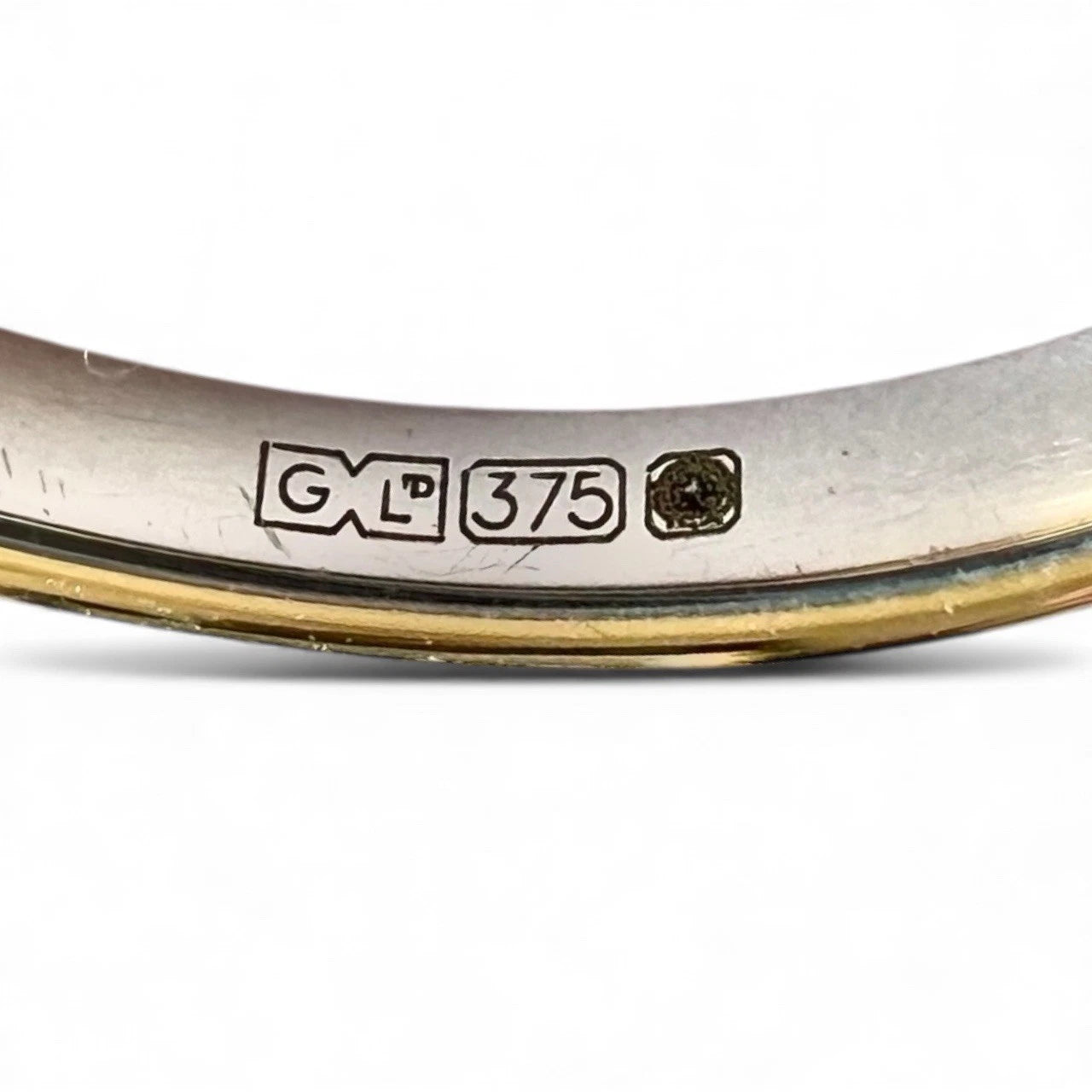 Close-up of a white gold ring with visible hallmark on a white background