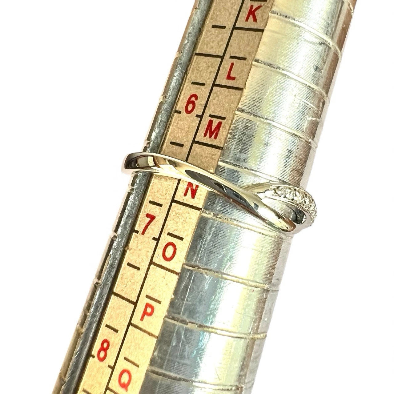 Close-up of a ring on a metal ruler with measurement markings.