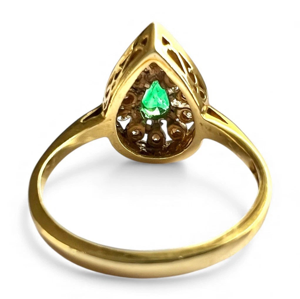 18ct Gold ring with a green emerald gemstone and diamond halo on a white background