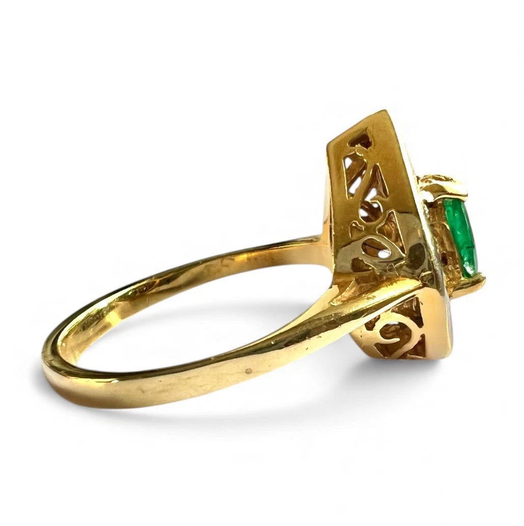 Gold ring with a green emerald gemstone side view on a white background