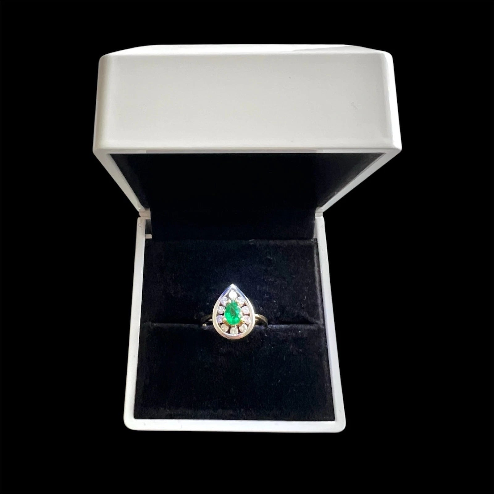 Emerald ring in a jewelry box on a black background