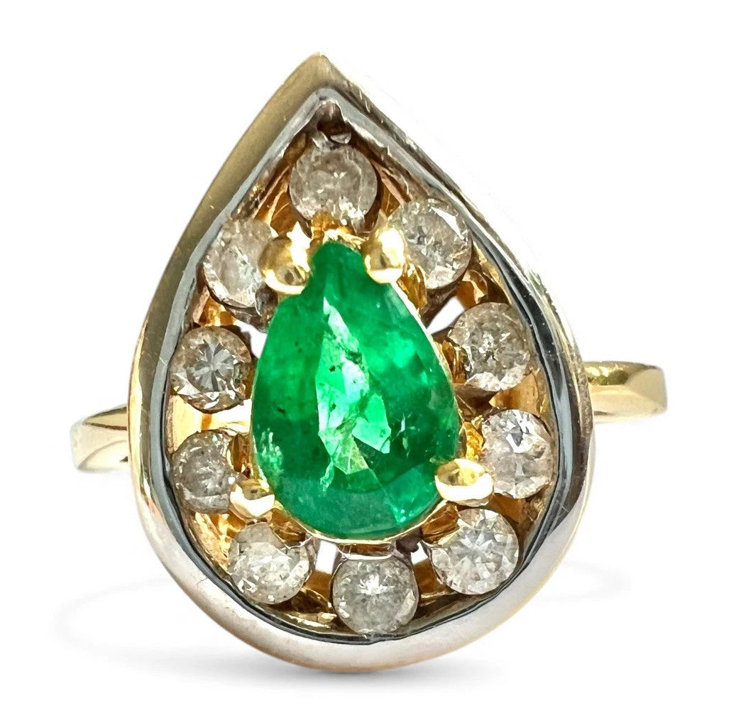 Gold ring with a green emerald gemstone and diamonds on a white background
