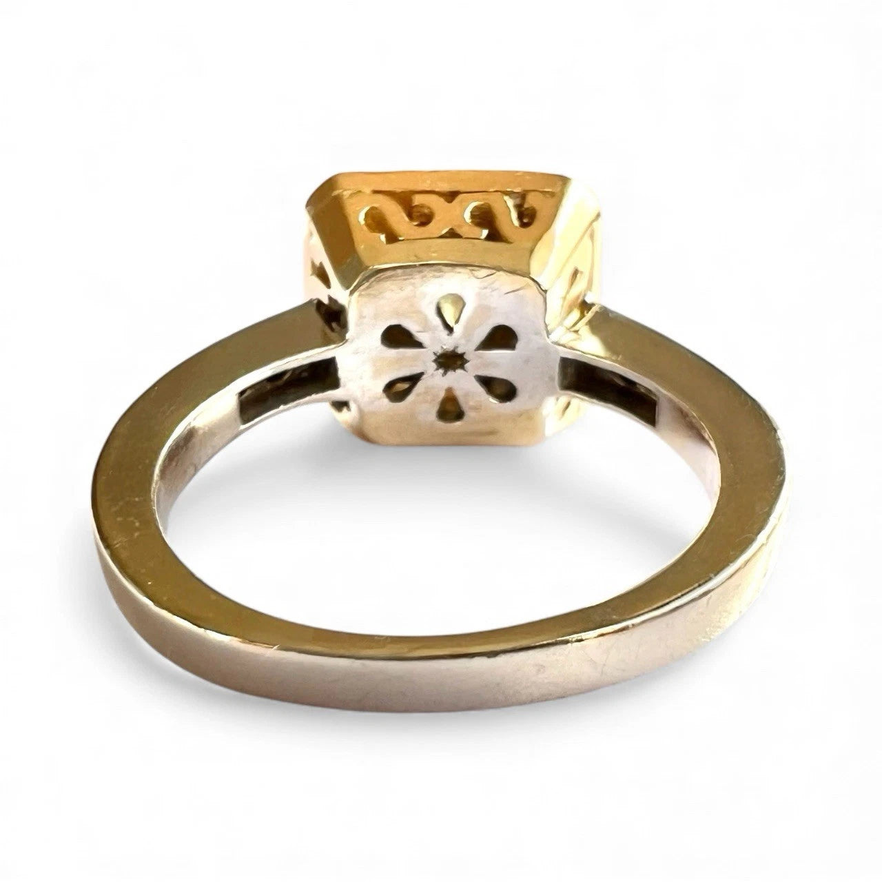 Gold ring with intricate design on a white background