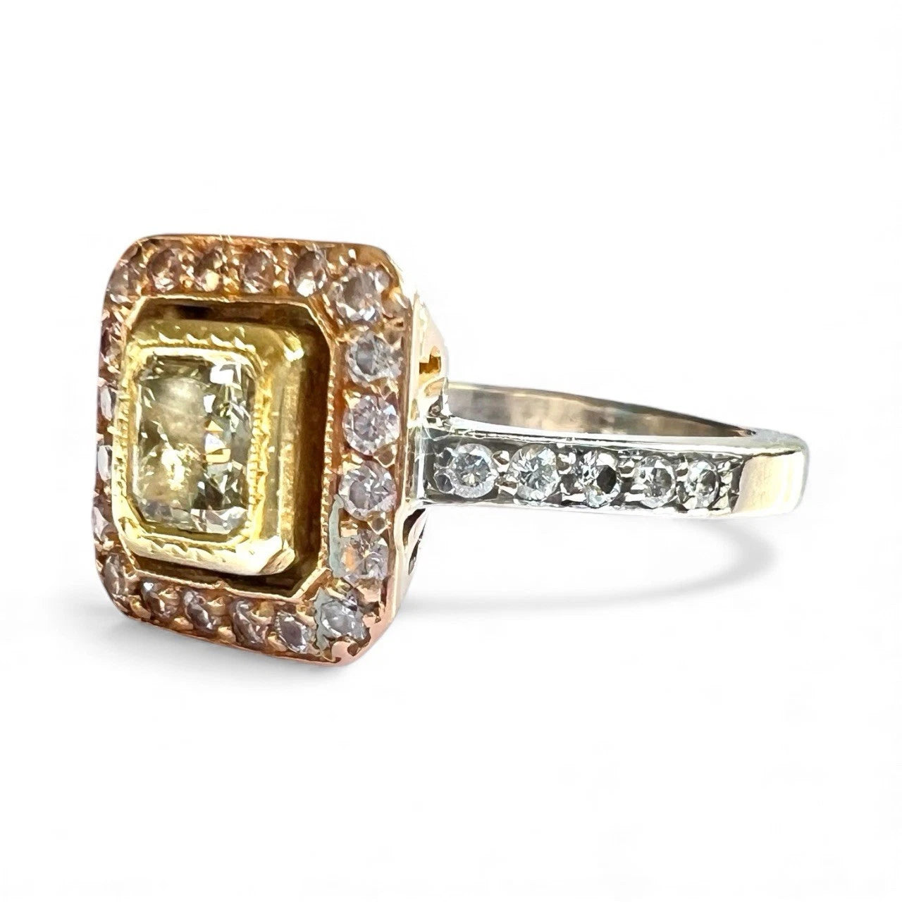 Gold ring with a large yellow diamond and smaller diamonds on a white background