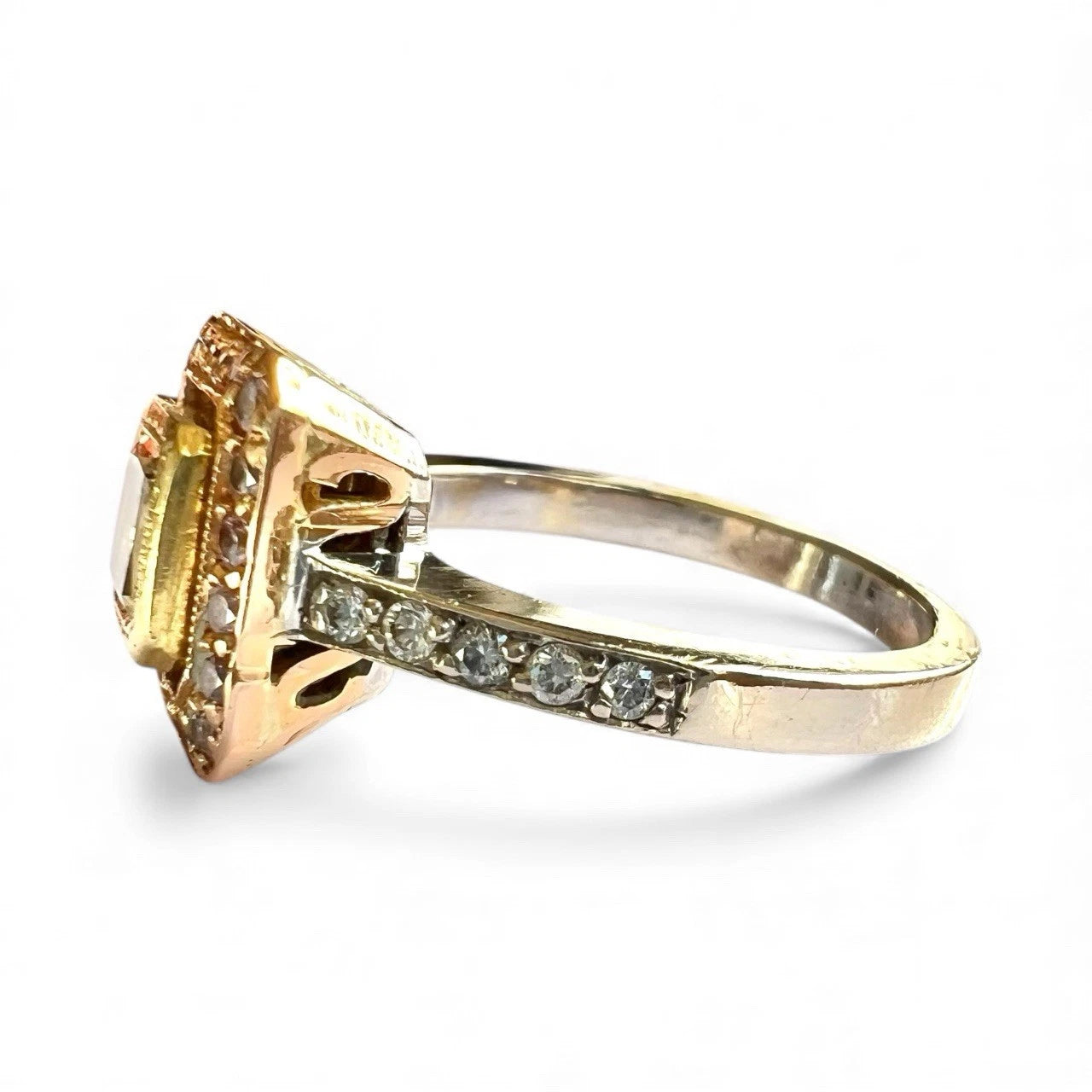 Gold ring with a large central yellow diamond and smaller fancy pink diamonds on a white background