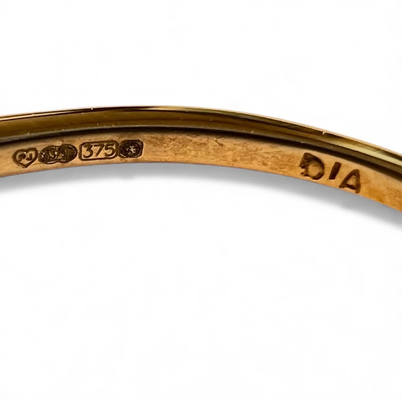 Gold ring with 'DIA' engraving and hallmark on a white background. Close up view