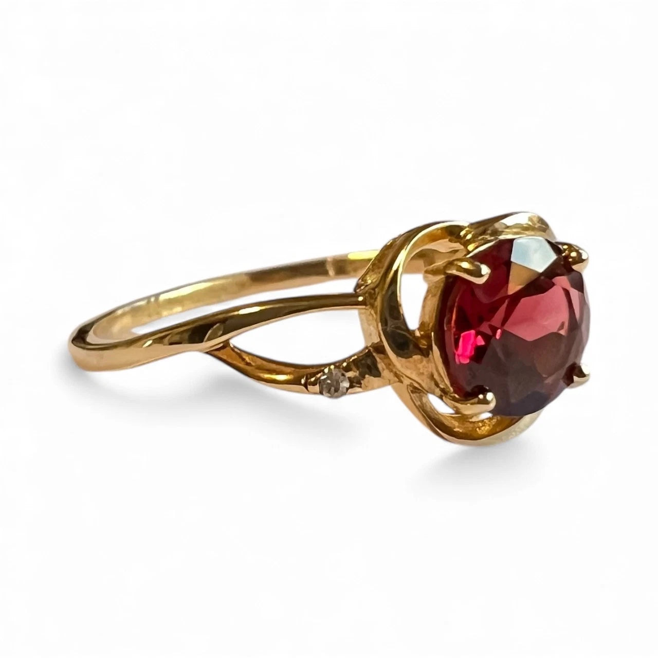 Gold ring with a red gemstone on a white background