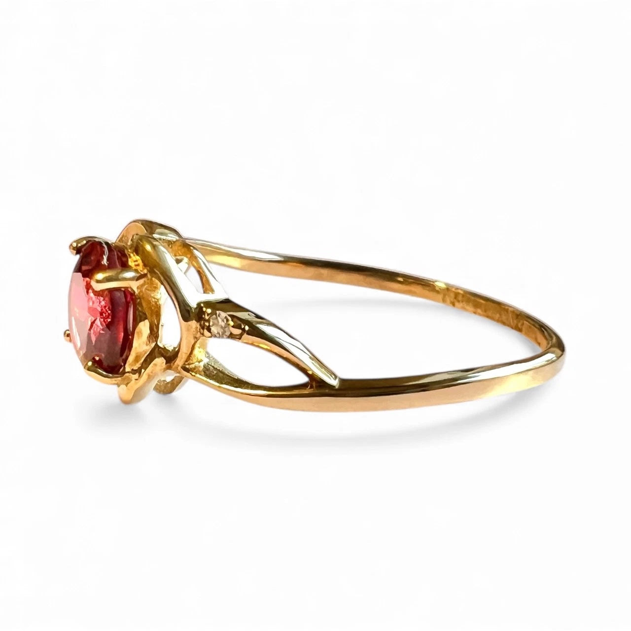 Gold ring with a red gemstone on a white background