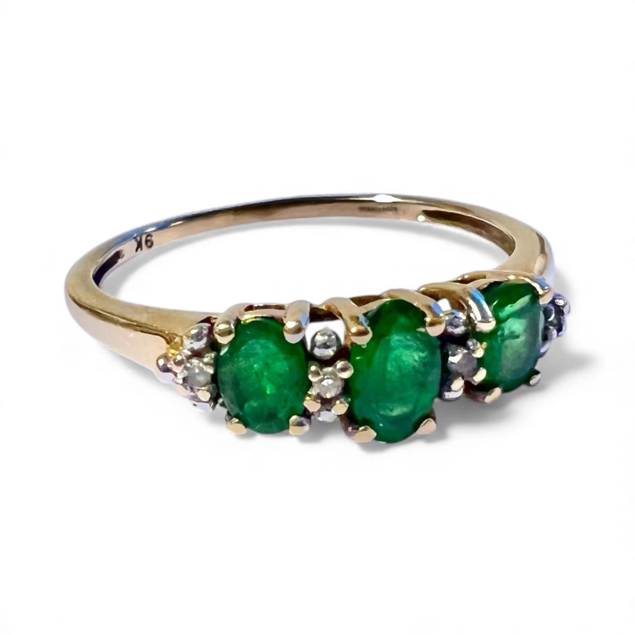 Green diopside and diamond gold ring close up on a white background 