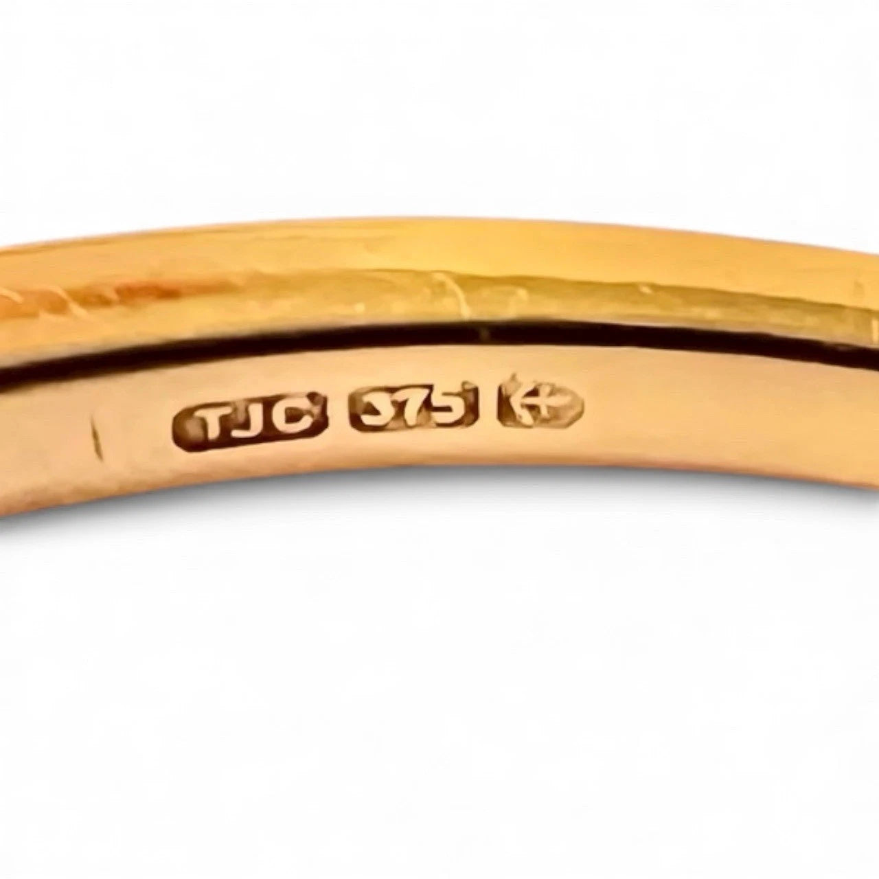 Gold ring close up of hallmark on a white background 