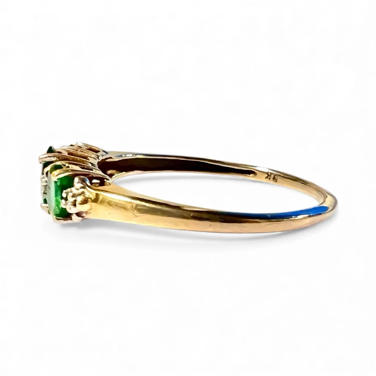 Side view gold ring set with oval cut Green diopside and diamonds on a white background 