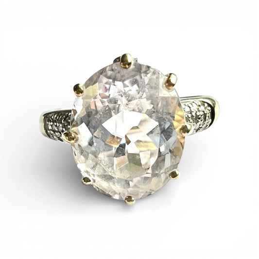 Gold ring with a large quartz and diamond on a white background