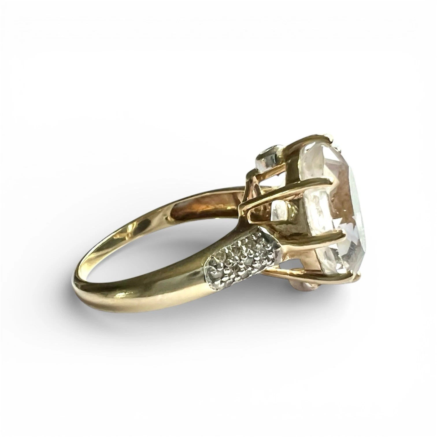 Gold ring with a large diamond and smaller diamonds on a white background